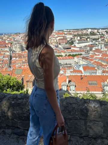 Girl standing in front of buildings in Lisbon.